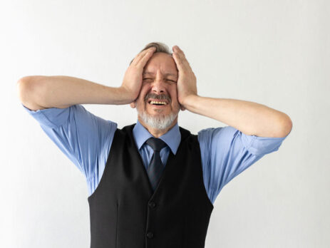 man holding his head from having regrets from selling his business