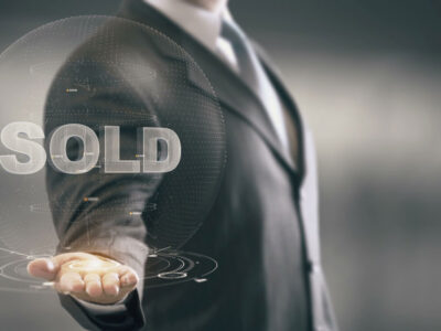 Business man holding a bubble with the word sold in it.