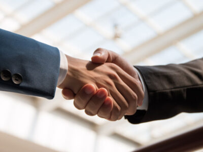 Two men shaking hands after closing the sale of a business
